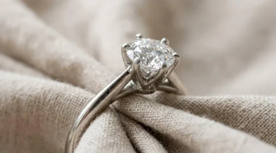 Gros plan d'une bague de fiançailles en platine avec diamant, montrant les détails du serti et la lumière naturelle
