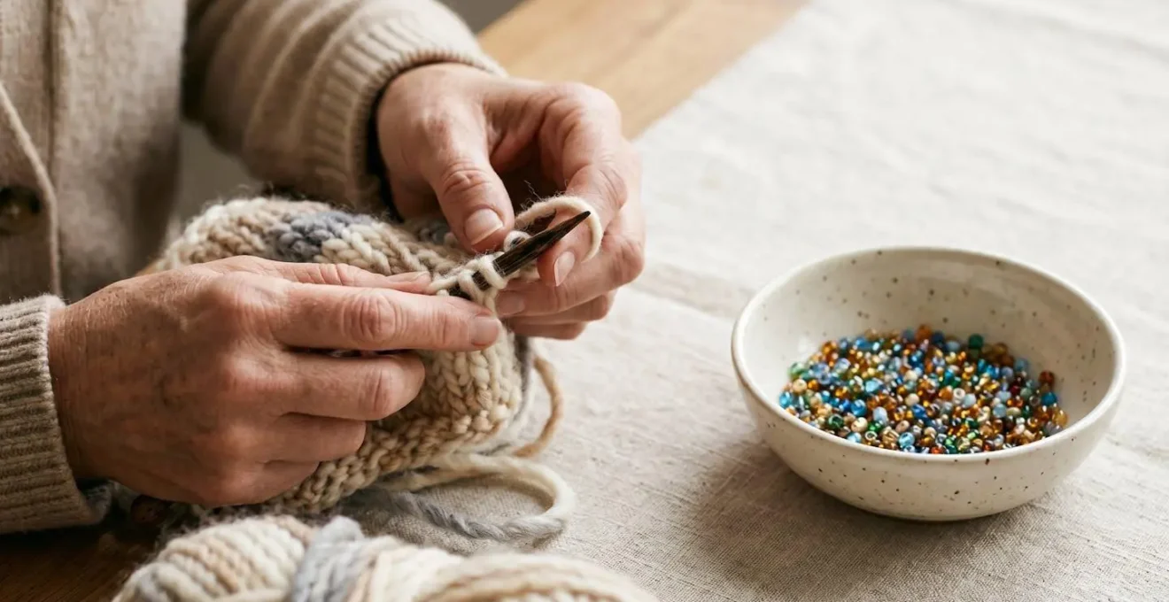 Gros plan sur des mains en train de tricoter avec des perles à proximité dans une lumière apaisante