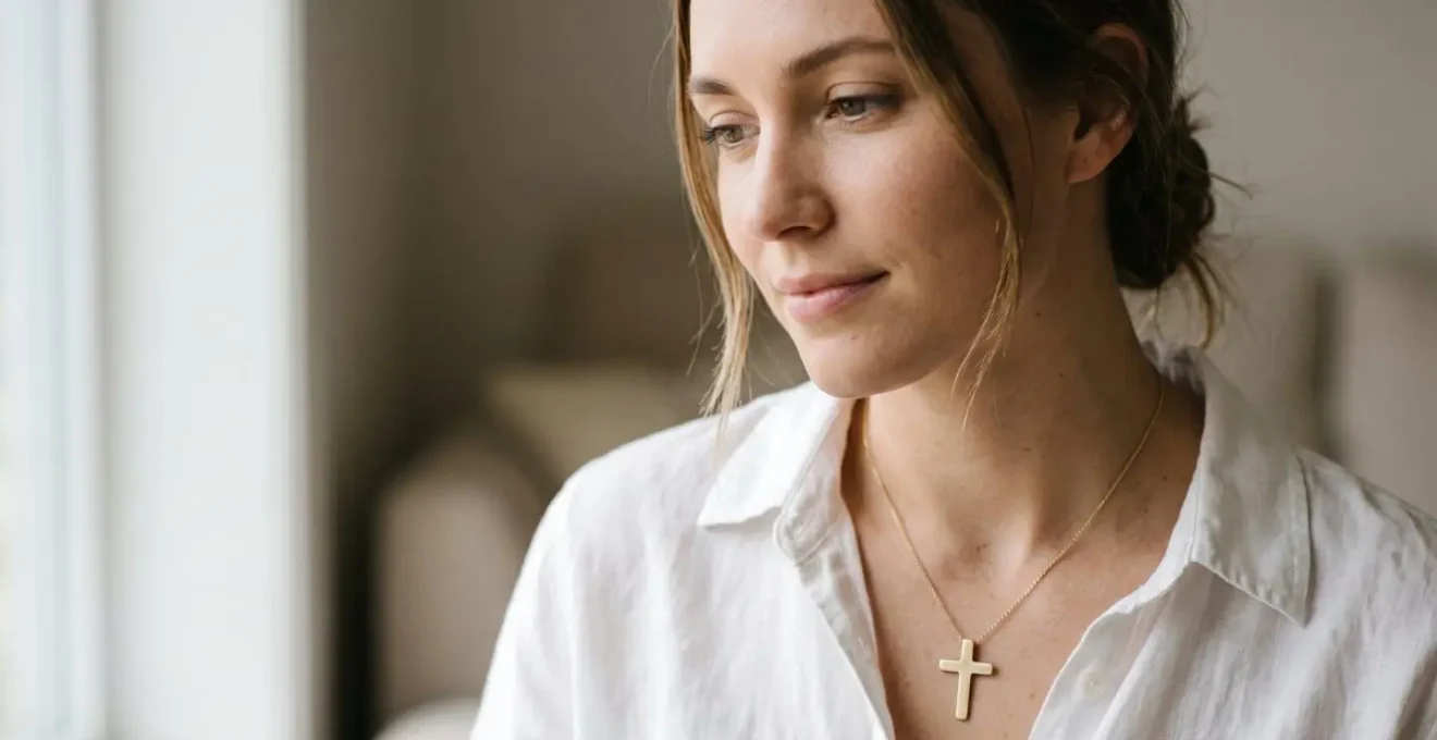 Femme portant une croix en pendentif délicate sur une chaîne fine, style minimaliste et élégant